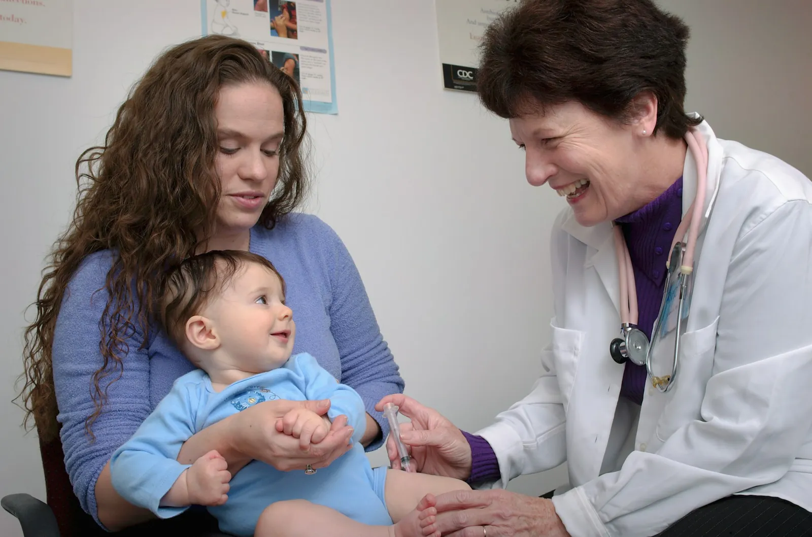 A mother holding her baby's hands at a clinic visit